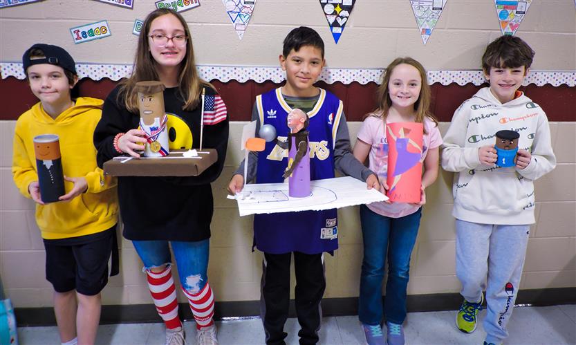 Students hold up Characters in a Can